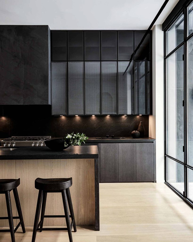 Artful juxtaposition of dark cabinets and light wood in a kitchen with lots of natural light.