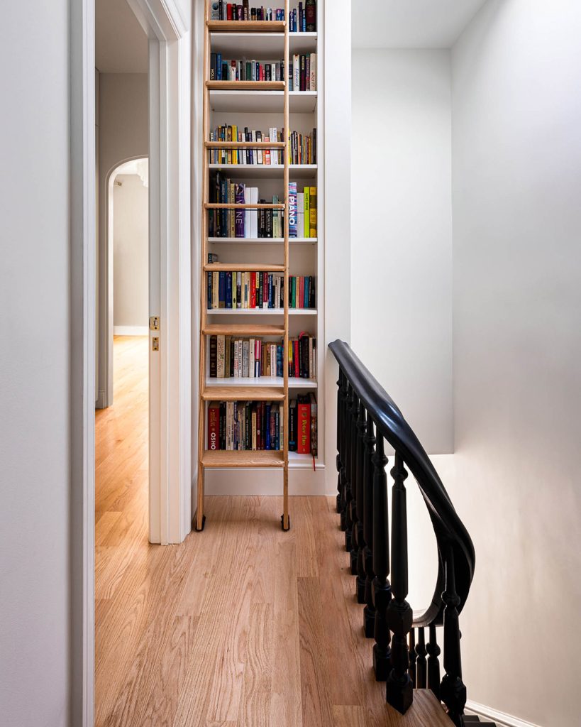 A built-in bookshelf at the top of the stairs.